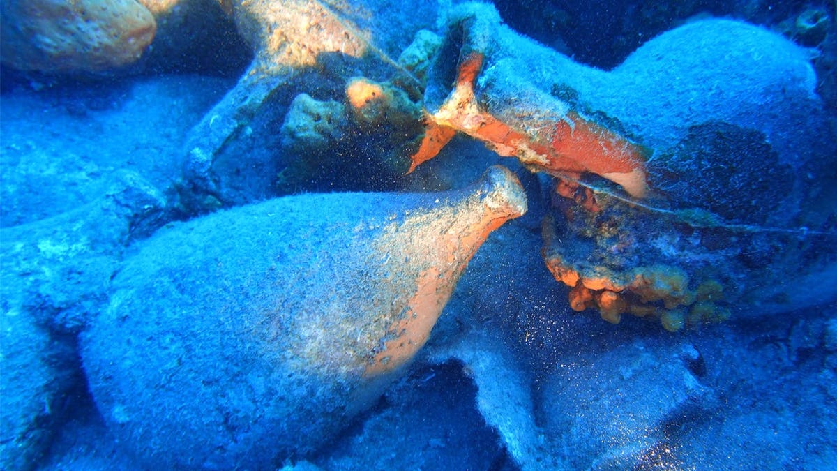 Ancient vessel sits among shipwreck artifacts.