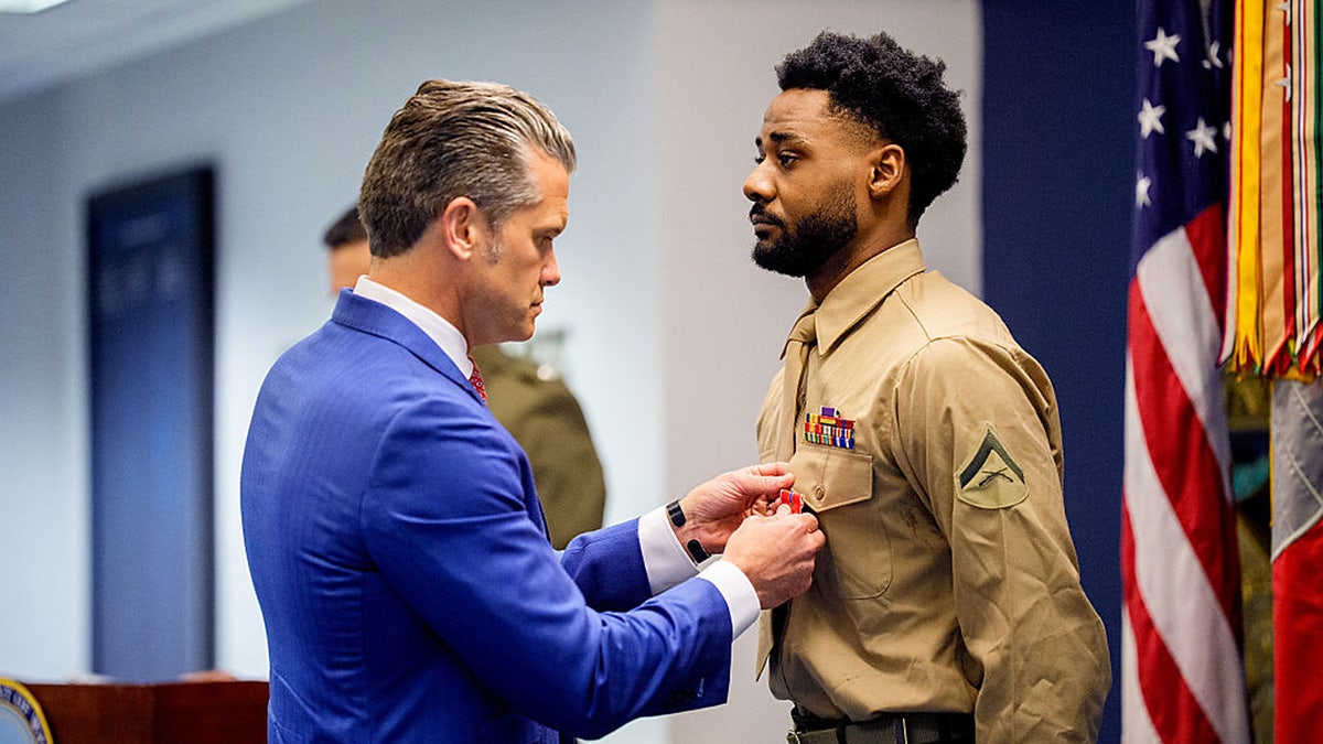 War Secretary Pete Hegseth pins a medal on Marine Lt. Col. Jordan Houston during an event to honor Marines who were serving during the 2021 Abbey Gate bombing,