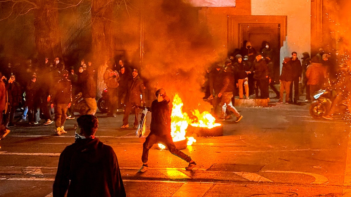 Protesters block a street as a crowd gathers during a demonstration in Tehran.