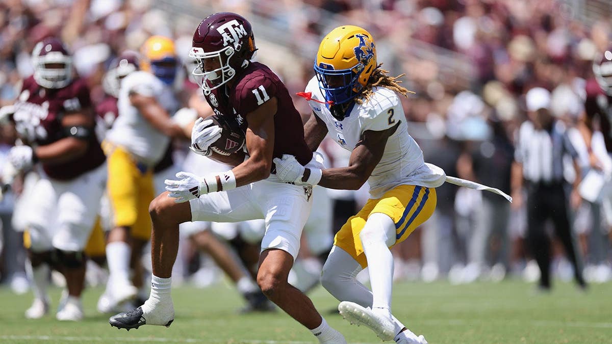 Jacob Bostick runs with the ball while defended by Levi Wyatt during a football game.