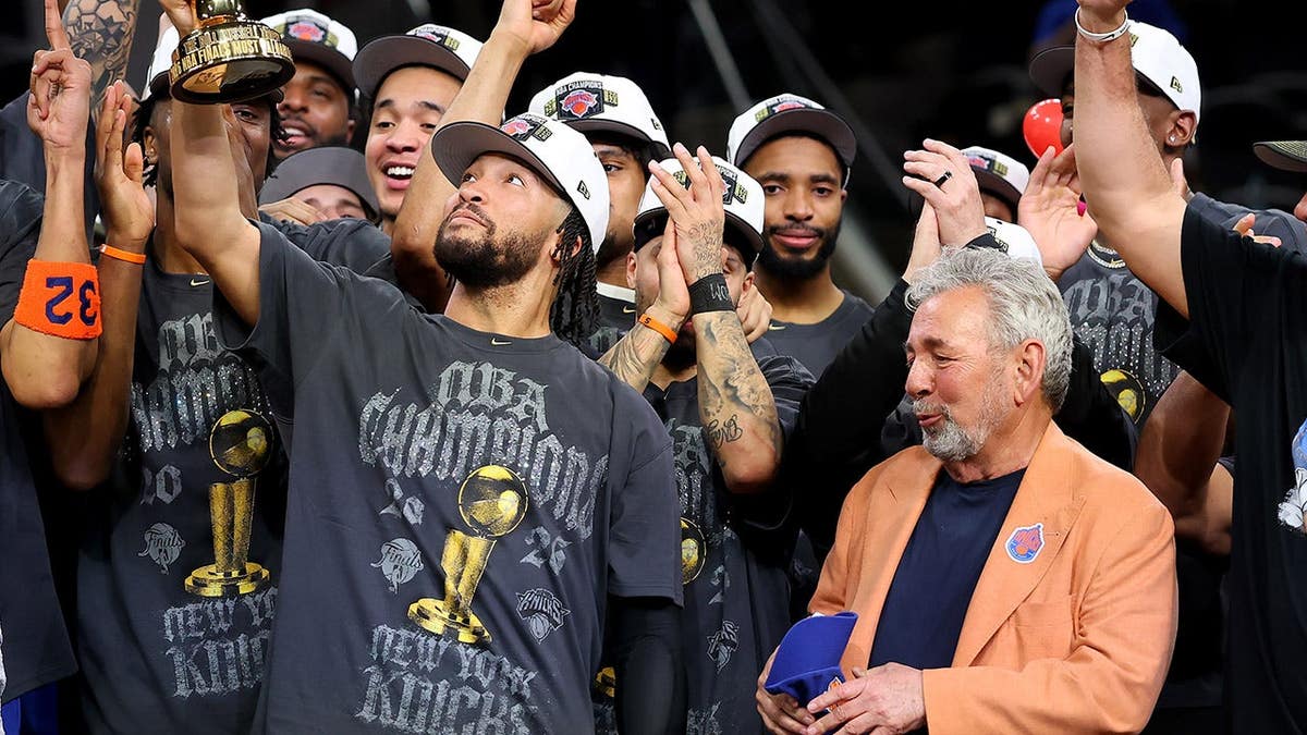 Jalen Brunson lifts the Bill Russell NBA Finals MVP Award trophy in San Antonio.