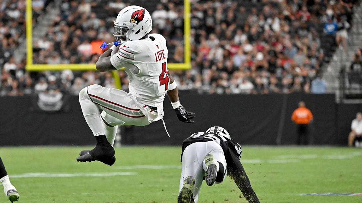 Jeremiyah Love spins away from Hezekiah Masses during a preseason NFL game.