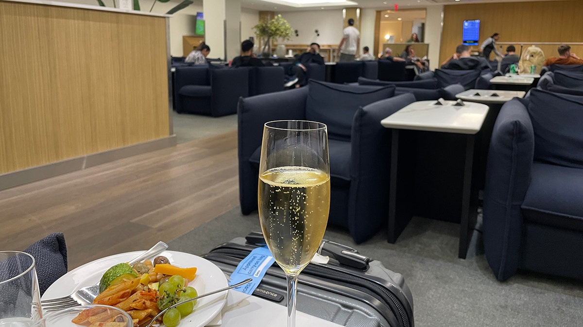 Champagne and a plate of food at an airport lounge at JFK.
