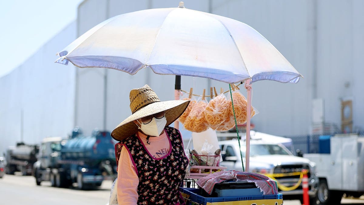 Lupe Gonzalez pushes her cart away from Lineage Logistics warehouse in Boyle Heights.
