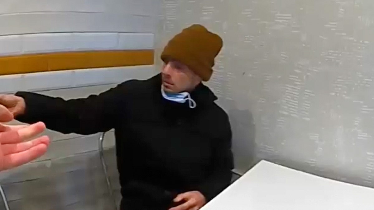 Luigi Mangione at a McDonald's speaking to a police officer.