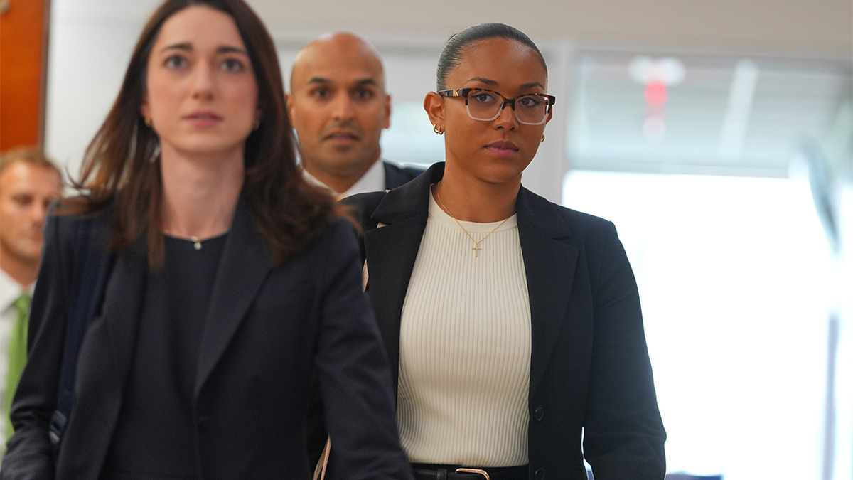 McKenna West walks through a Dallas courthouse with her legal team