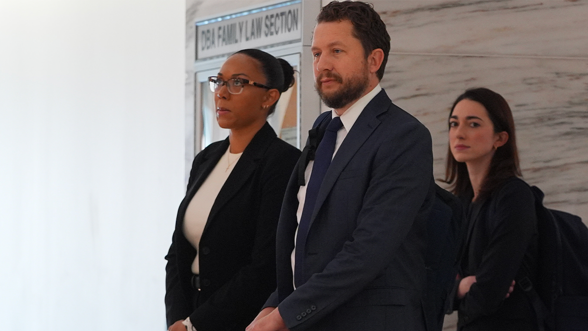 McKenna West stands with her legal team