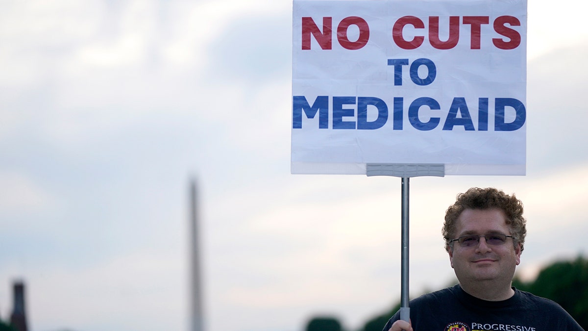 A protestor holds a sign at protect Medicaid lights up Capitol amid budget showdown, on May 07, 2025 in Washington, DC.