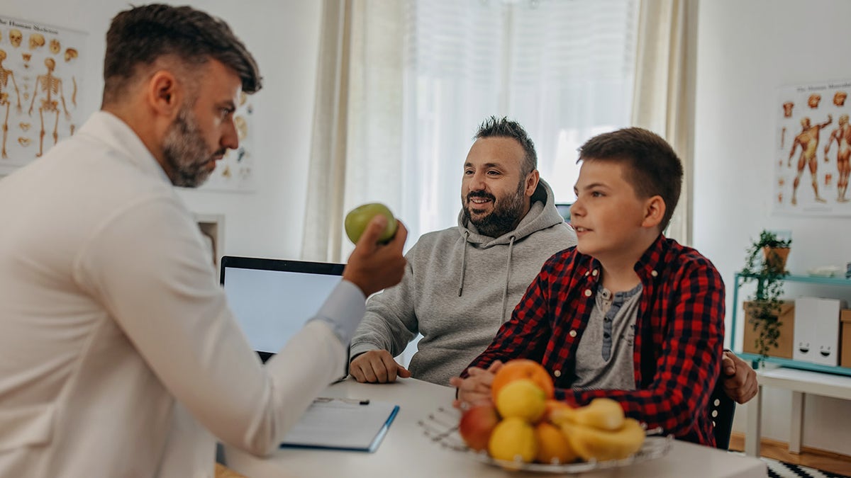 obese child at doctor's with father