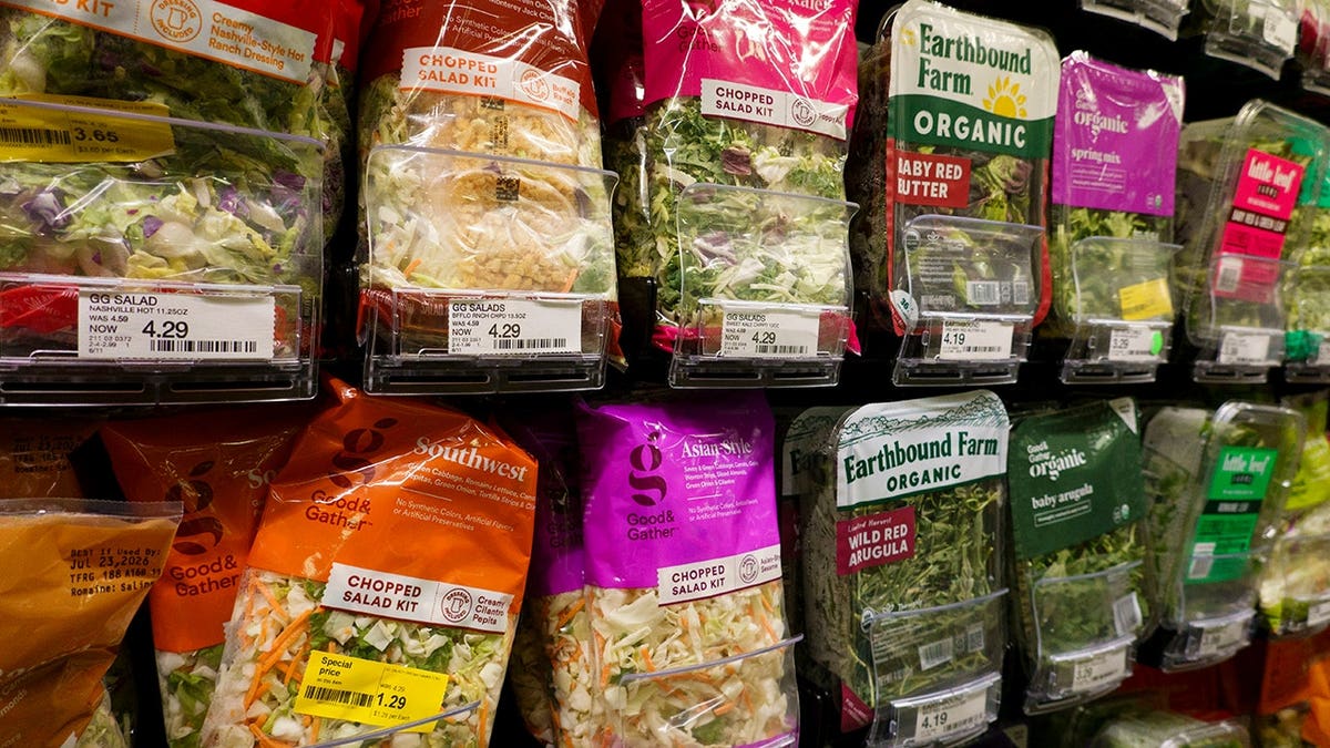 Packaged salad mixes displayed in a refrigerated produce section of a Target store.