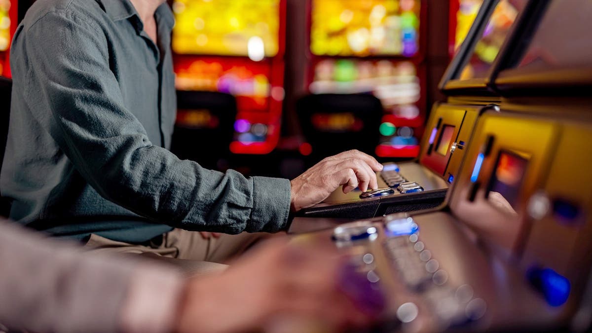 A man plays a slot machine at a casino.