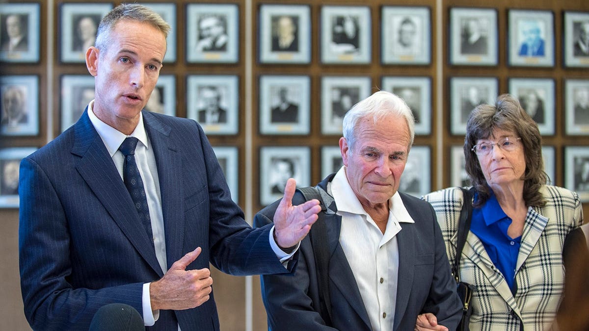 Matt Murphy speaks at news conference as Steve and Raquel Herr, parents of murder victim Samuel Herr, listen.
