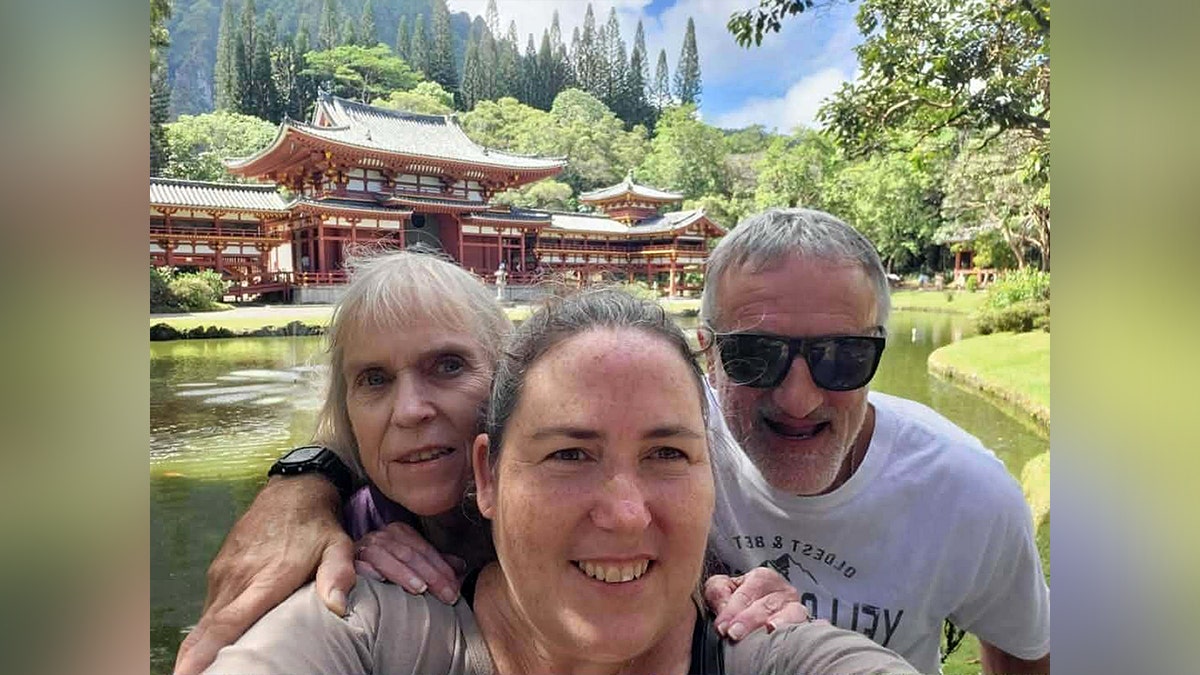 Family taking selfie together outdoors in front of a temple