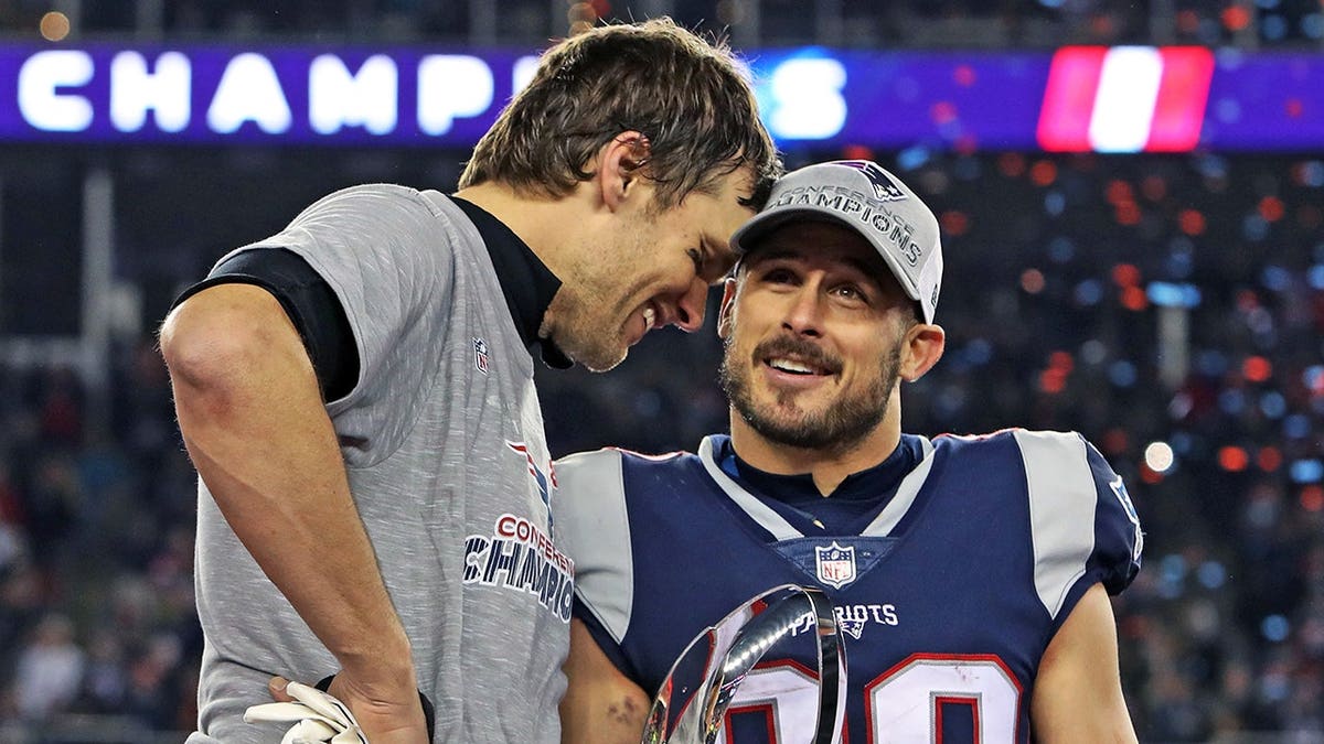 Tom Brady celebrates with Danny Amendola holding the Lamar Hunt Trophy.