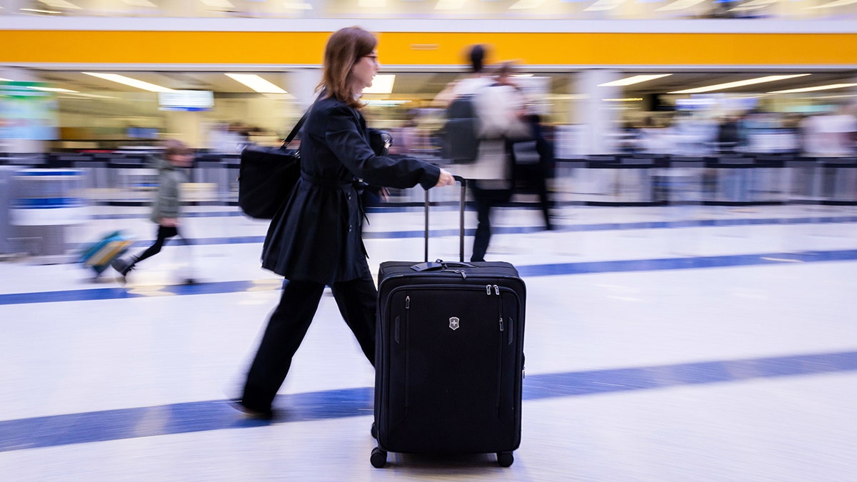 A traveler walking inside a terminal at Los Angeles International Airport.