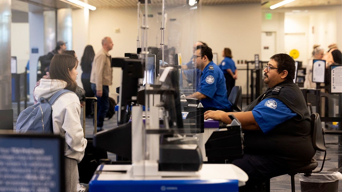 Traveler having documents checked by TSA officer at airport security checkpoint