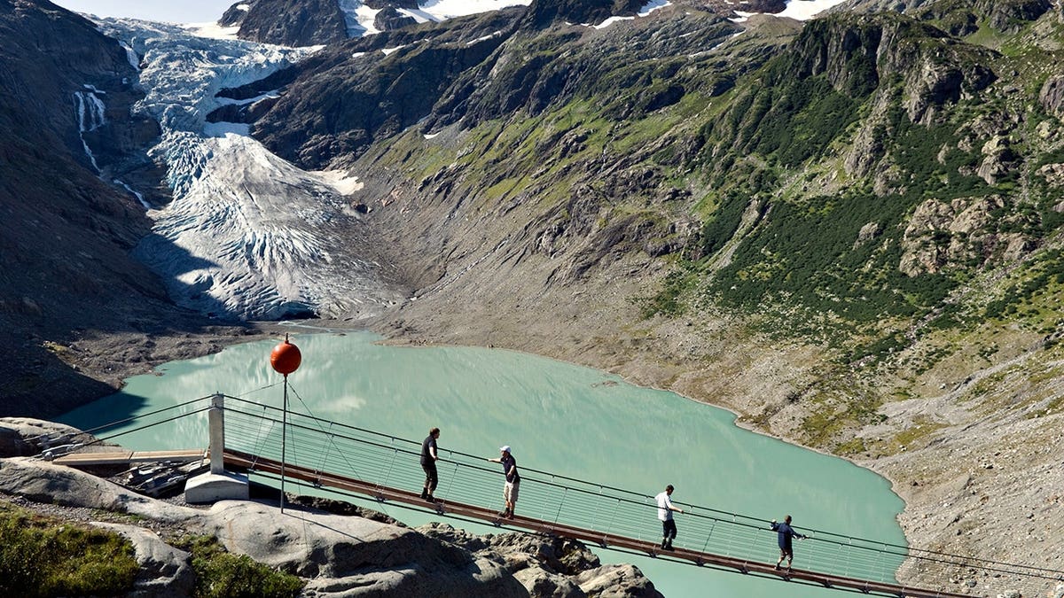 Trift suspension bridge spans across a glacier valley in Valais, Switzerland.