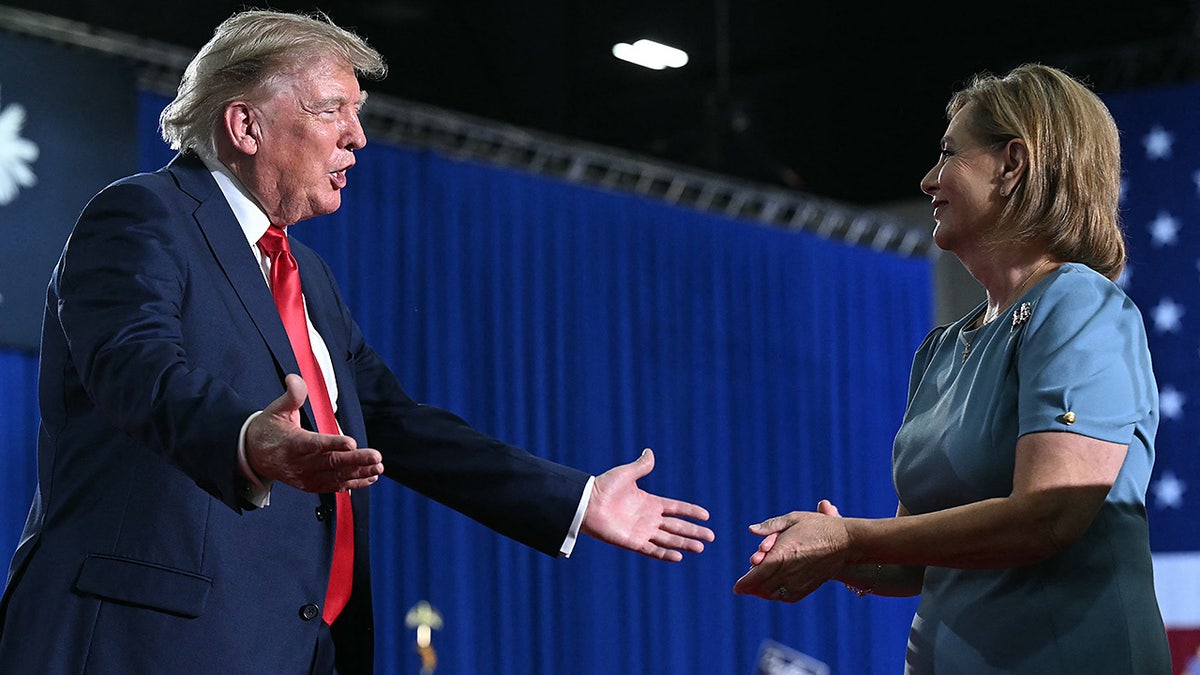 US President Donald Trump congratulates US Senator Darline Graham after she spoke during a campaign rally at Myrtle Beach Convention Center in Myrtle Beach, South Carolina on August 21, 2026. (Photo by SAUL LOEB / AFP via Getty Images)