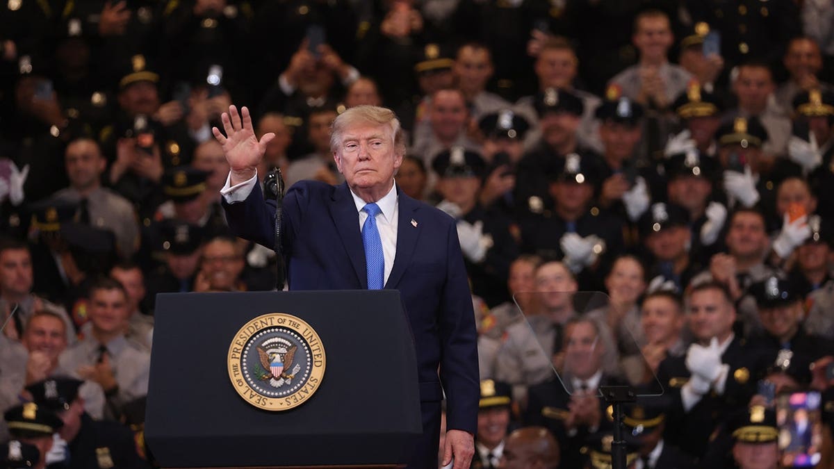 Donald Trump speaks at a podium in Garden City, New York.