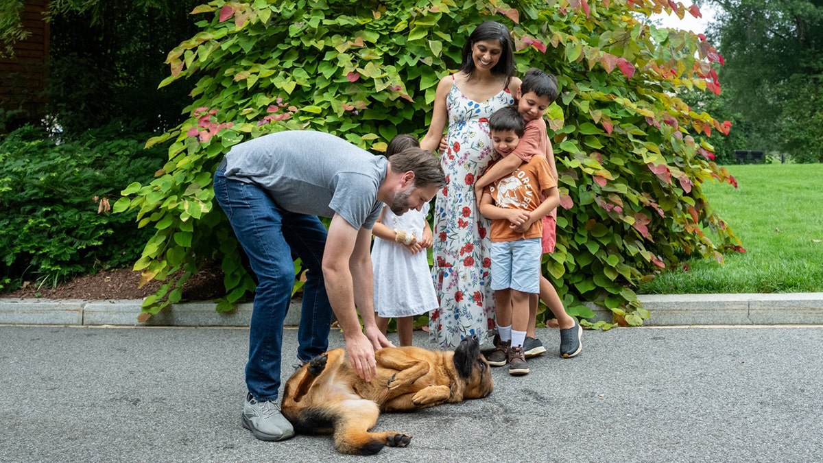 JD and Usha Vance with their family and dog outside.