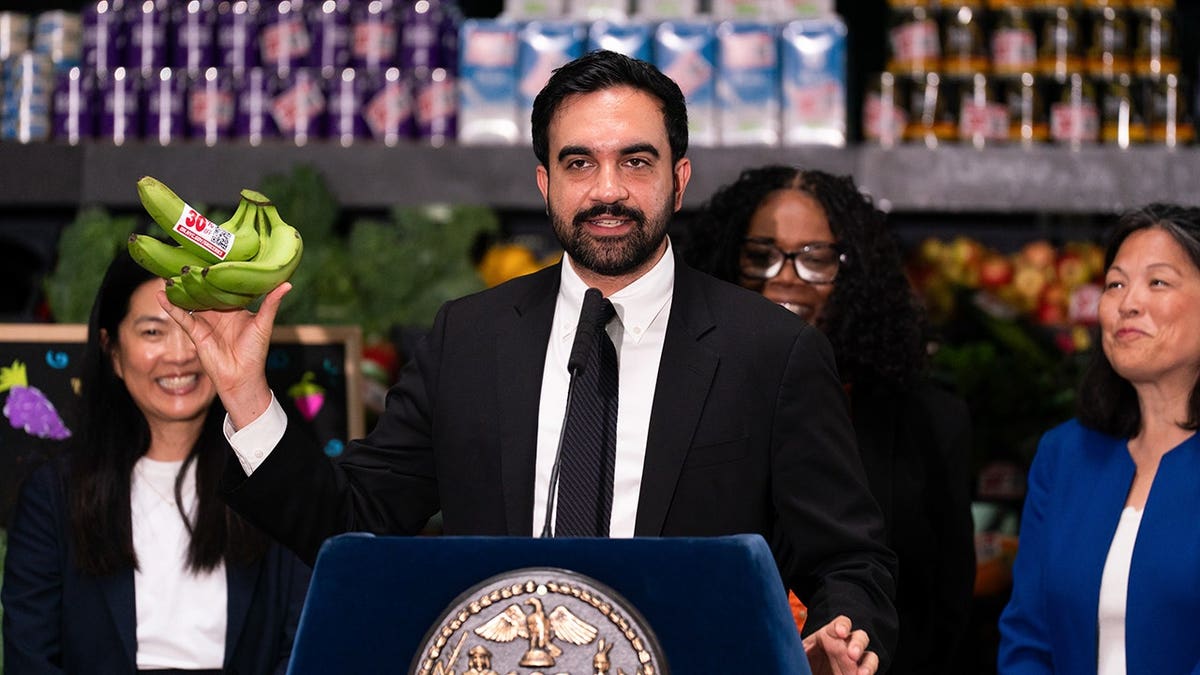 Zohran Mamdani, mayor of New York, holds up bananas with a 30% off sticker.