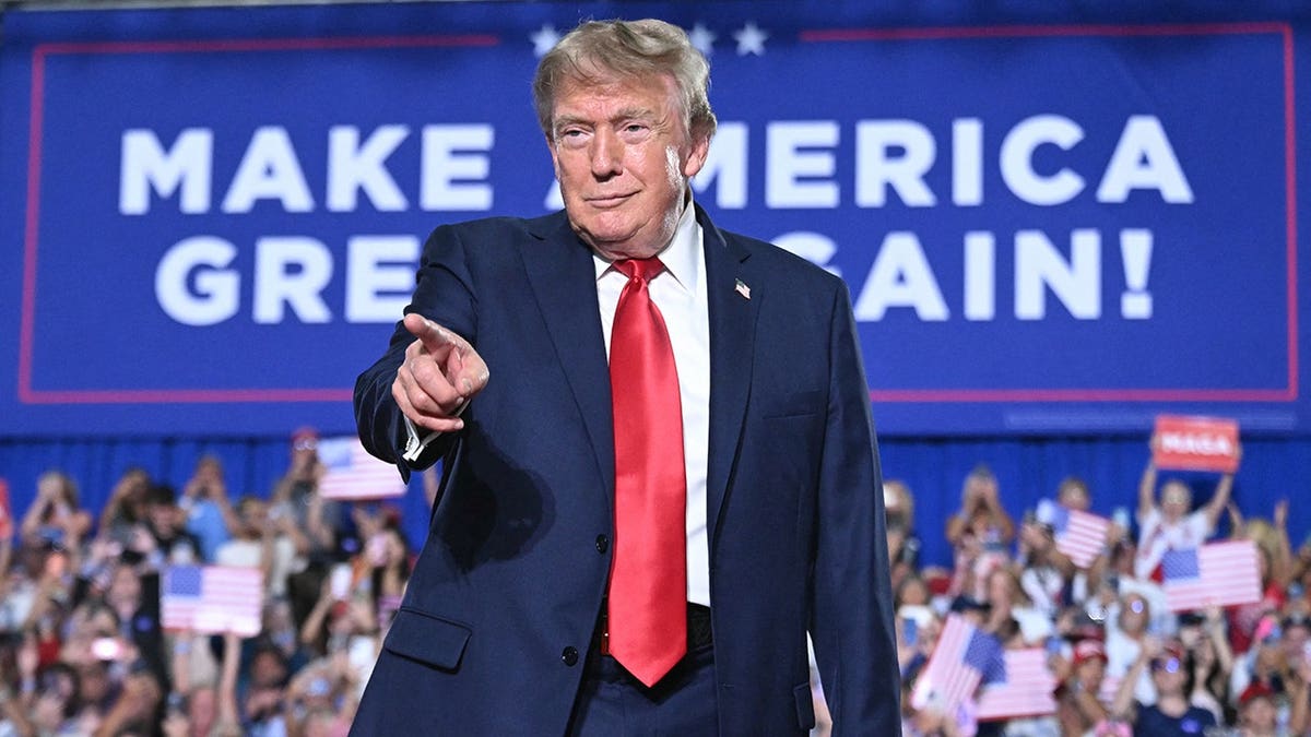 President Donald Trump points as he arrives to speak during a campaign rally.