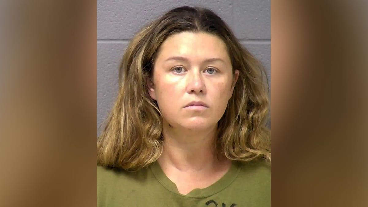 Booking mugshot of Corie A. Walsh facing forward against a gray wall wearing an olive green shirt.