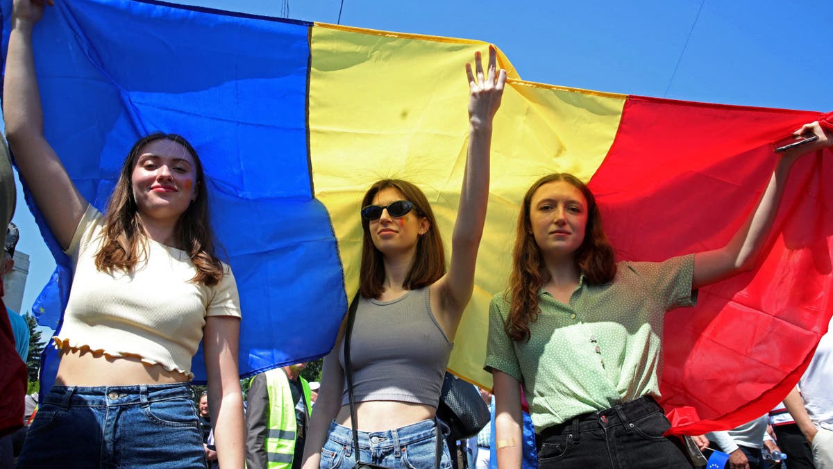Women hold a Moldovan flag during a rally to support a European path for the country, in Chisinau, Moldova, May 21, 2023. REUTERS/Vladislav Culiomza