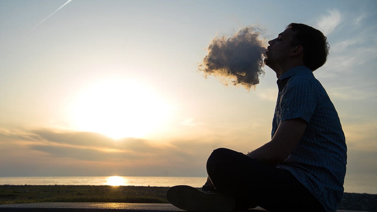 Stock imaging of man smoking on beach
