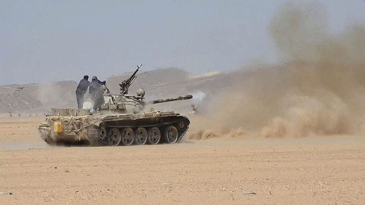 Members of the Saudi-backed Yemeni government forces fire a tank