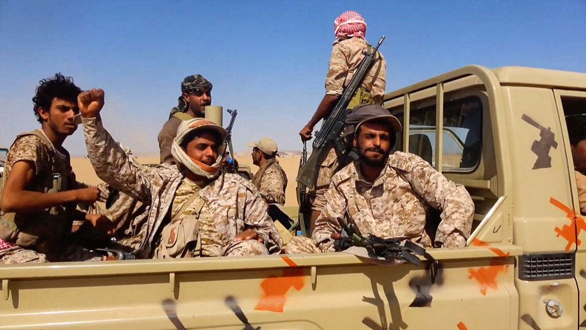Members of the Saudi-backed Yemeni government forces react during what they say to be clashes with Yemen's Iran-aligned Houthis