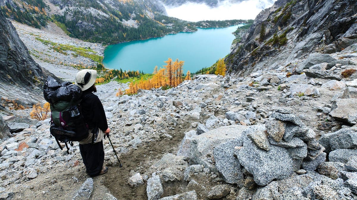 Backpacker viewing Colchuck Lake from Aasgard Pass, The Enchantments