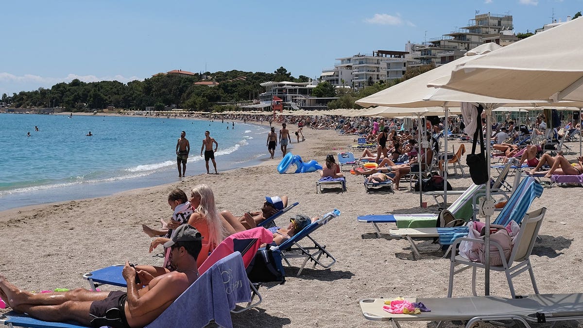 People relax at Akti Vouliagmenis beach resort in Vouliagmeni, Greece.