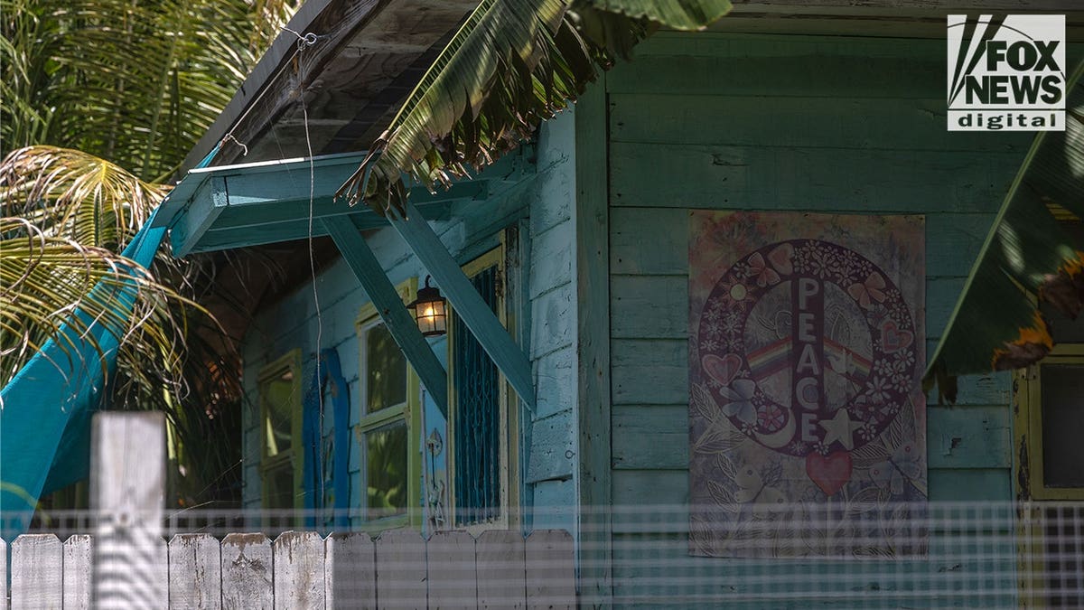A large "PEACE" poster hangs on the turquoise exterior of the Miami property listed as the address of the newly incorporated Arc of Justice nonprofit.