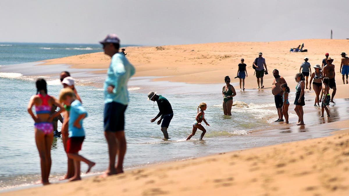 People stand along the shoreline of Coast Guard Beach.