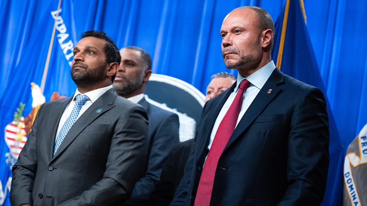 Two senior law enforcement officials stand side by side at a podium during a press briefing.