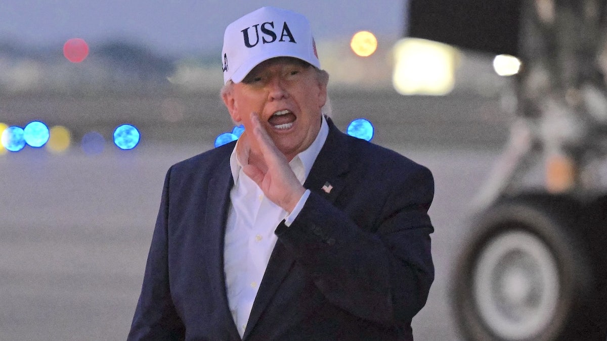 president donald trump shouts to reporters on the tarmac after deplaning from Air Force One