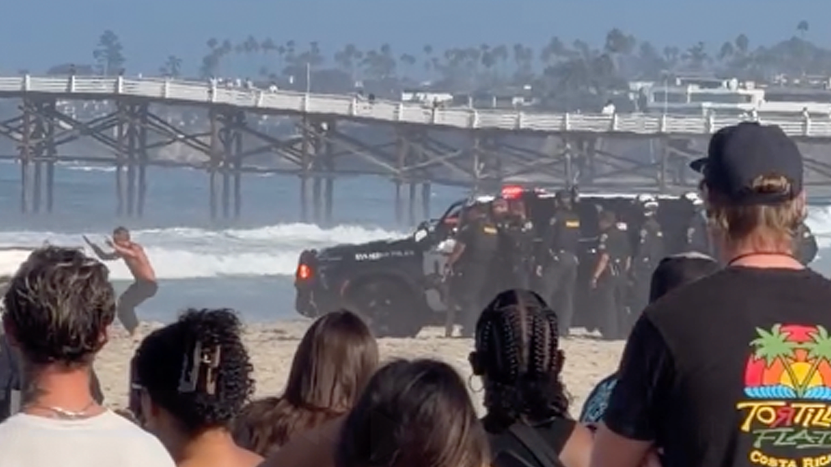 Police gather around a pickup truck on Pacific Beach after a pursuit through San Diego