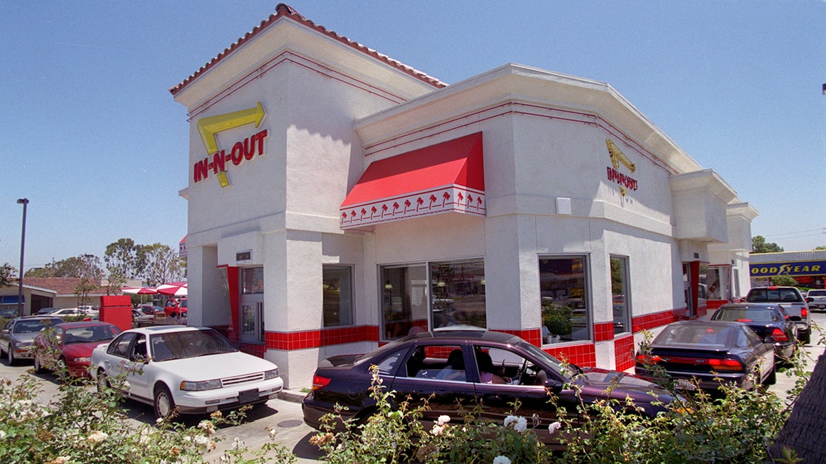 A line of vehicles is wrapped around an In-N-Out building.