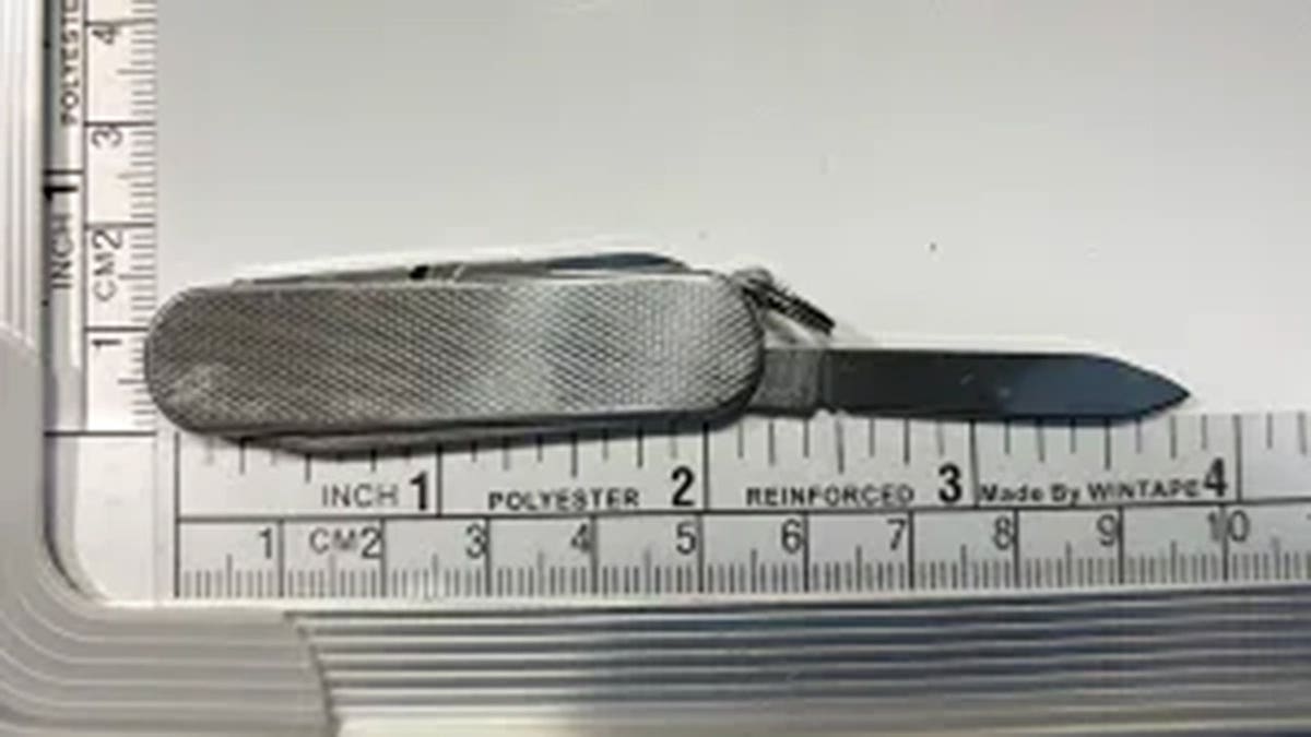 A knife next to a measuring tape.