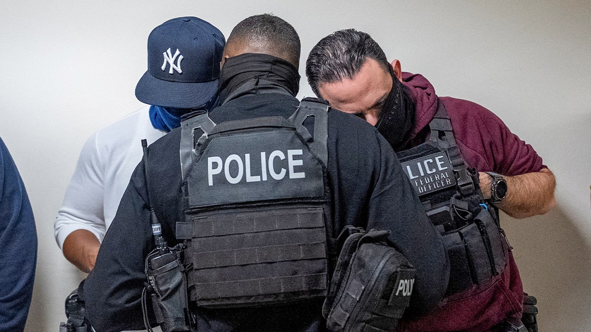 Federal immigration officers consult as they wait for respondents to depart from their hearings to conduct targeted detainments at U.S. immigration court in Manhattan, in New York City, Oct. 24, 2025.