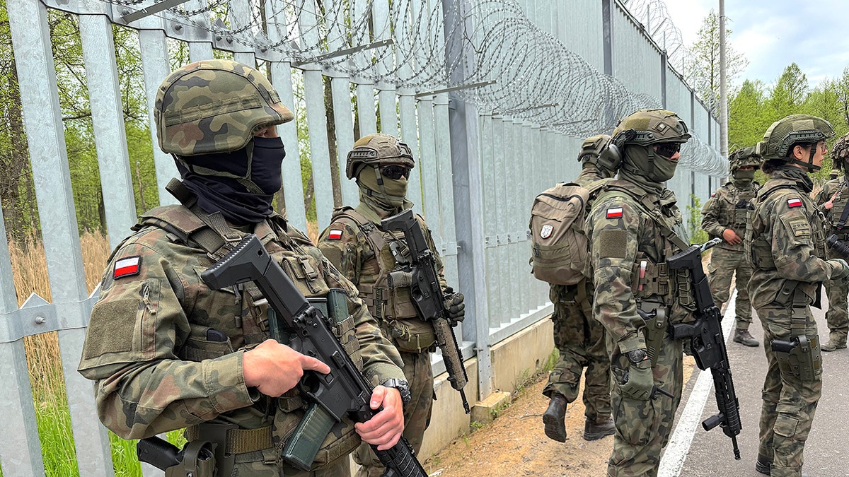 Polish soldiers stand guard at the border with Belarus.