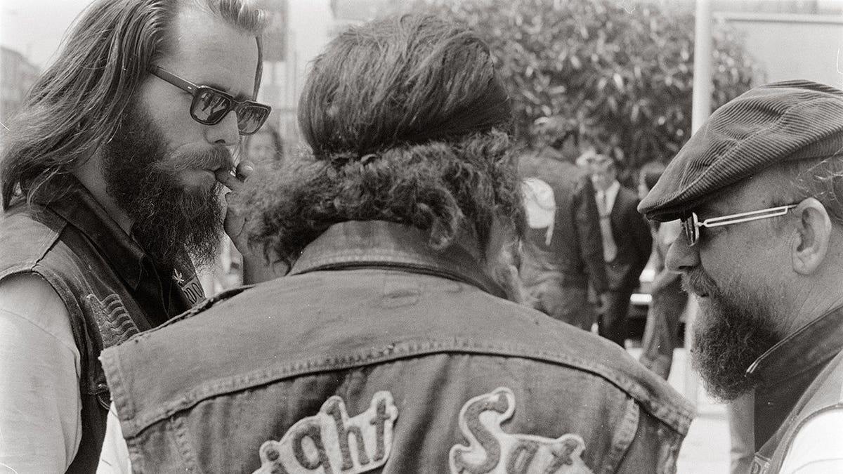 Three bikers stand together talking in Venice, California, mid-1972.