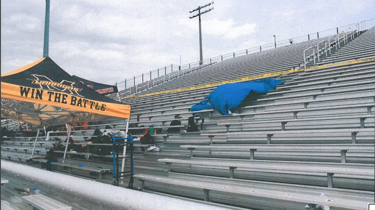 image shows track tent and bleachers with tarp and crime tape