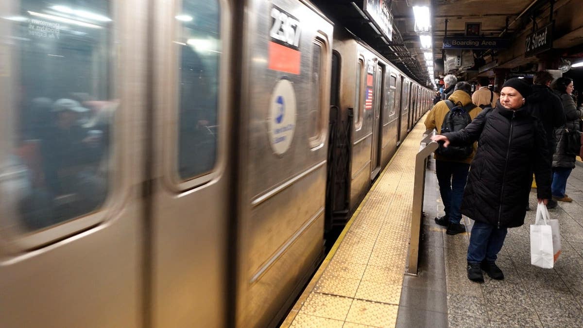 People wait to board a 1-line train at the 72nd Street subway station