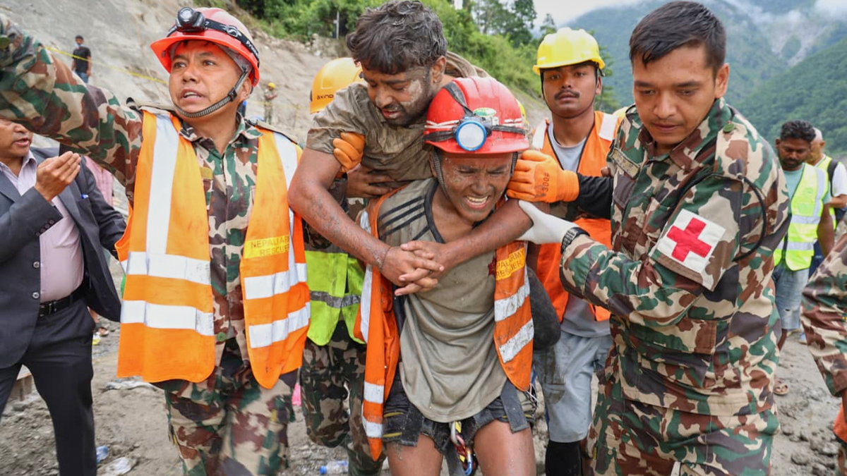 A rescuer carries one of the Nepal workers who was trapped