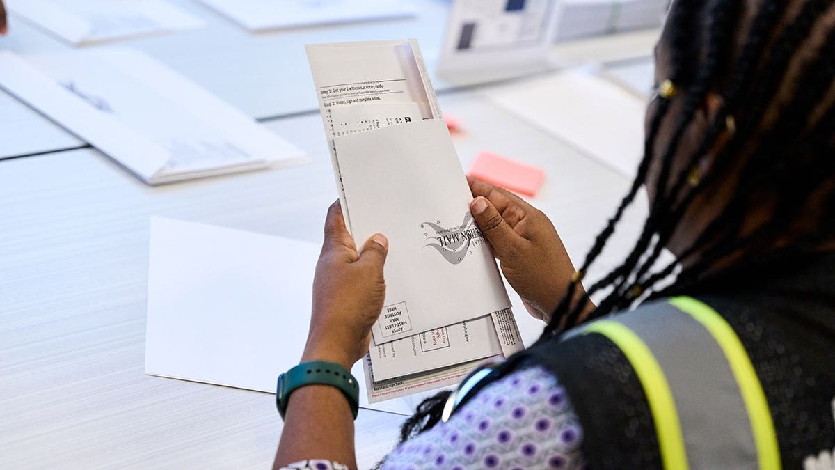 Wake County Board of Elections employees prepare absentee ballots for mailing in Raleigh, N.C.